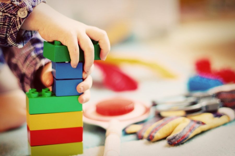 Kinderhände bauen Turm aus Bauklötzen