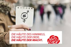 Geschlechtergleichheit als Forderung zum Internationalen Frauentag, eine Frau hält einen Zettel mit einem kombinierten Symbol für Männer und Frauen in der Hand