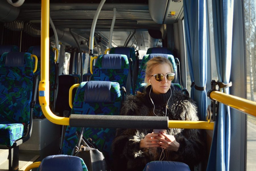 Stadtbussystem für Stade, Mädchen mit Kopfhörern und Smartphone fährt im Bus