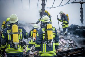 Feuerwehrkräfte im Einsatz in einer Brandruine